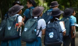 Photo of primary school students with backpacks and hats